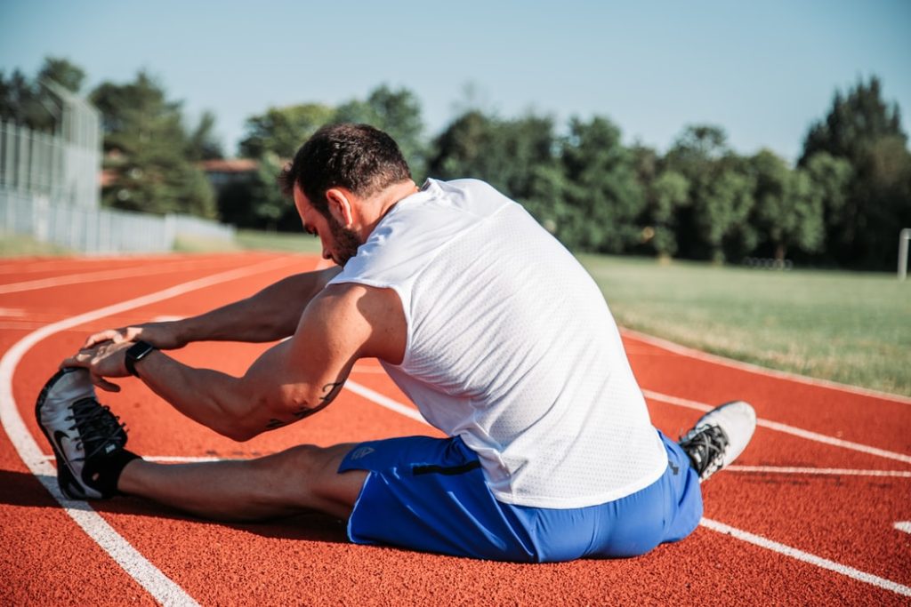 A man on a race track stretching